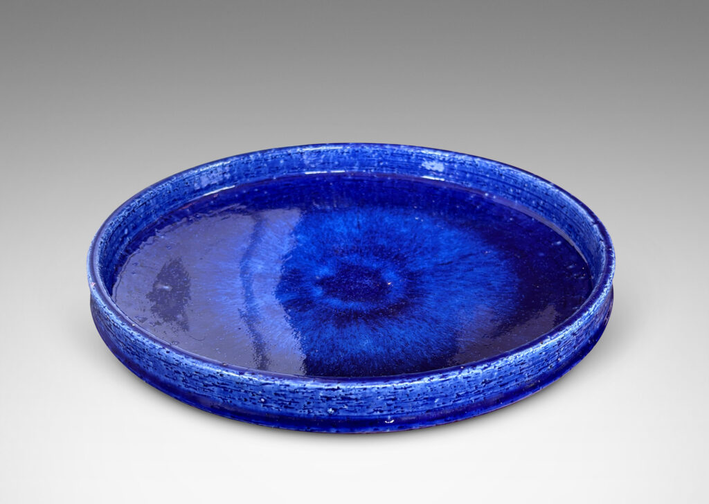 Gallery BAC wide concave form with shallow straight sides, in textured chamotte with a saturated blue glaze