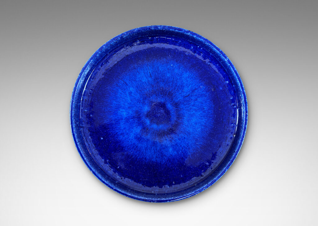 Gallery BAC wide concave form with shallow straight sides, in textured chamotte with a saturated blue glaze