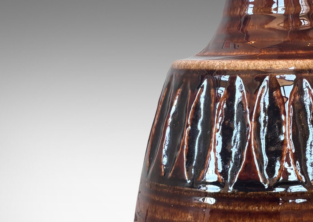 Gallery BAC pawn-like form with ridged texture, band of carved ovoids, and sprouting neck, glazed in a glossy brown