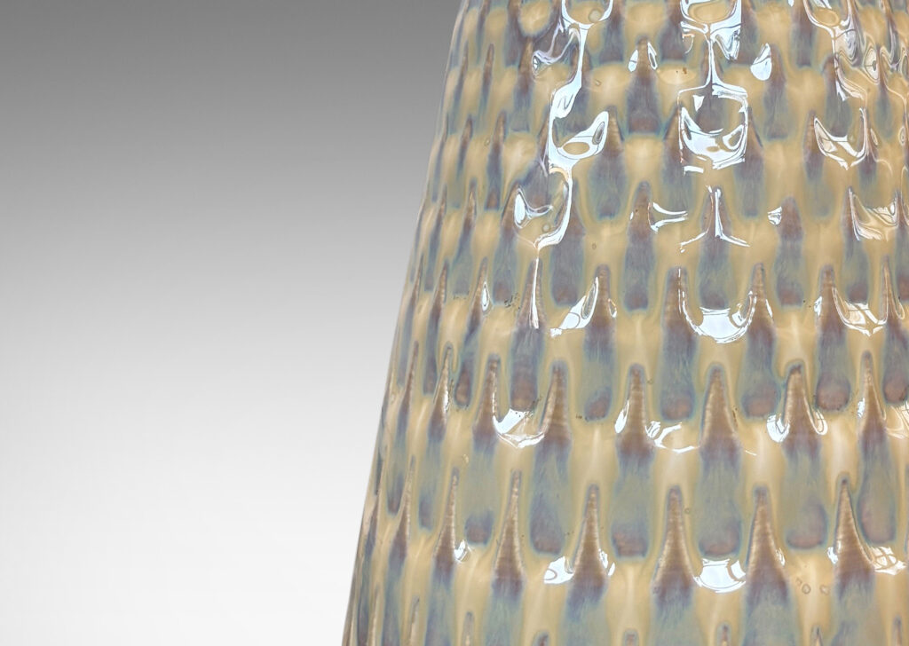 Gallery BAC conical forms with graduated scale pattern in relief, glazed in a light tan tone with pale blue accents