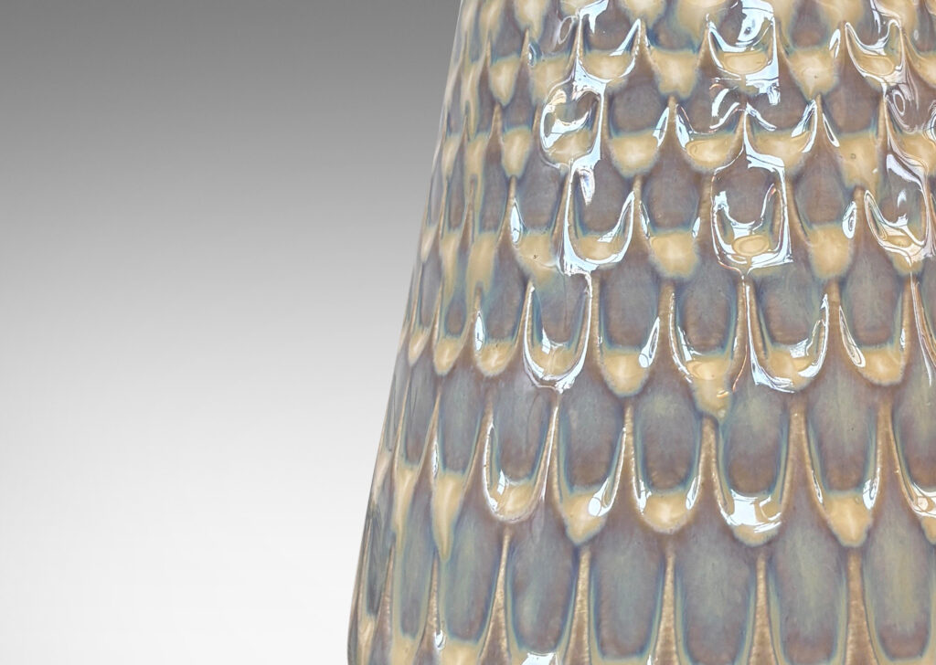 Gallery BAC conical forms with graduated scale pattern in relief, glazed in a light tan tone with pale blue accents
