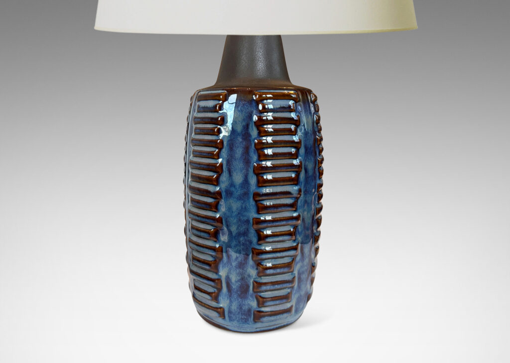 Gallery BAC swelling cylindrical forms ornamented with columns of relief bars, glazed in luster blue and matte brown