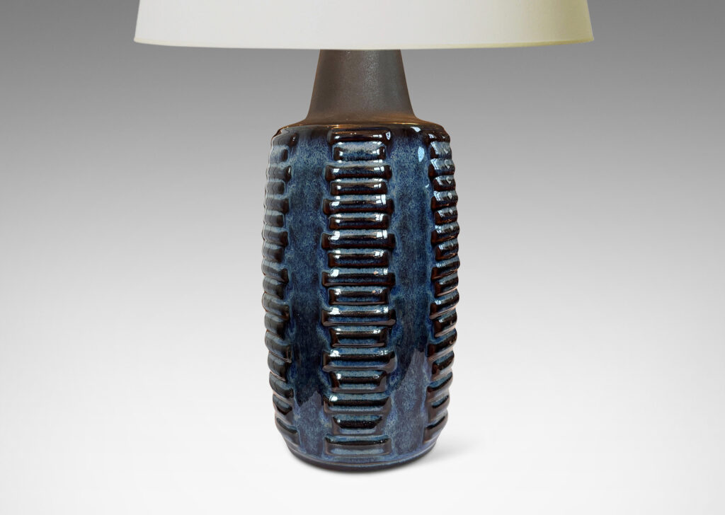 Gallery BAC swelling cylindrical forms ornamented with columns of relief bars, glazed in luster blue and matte brown