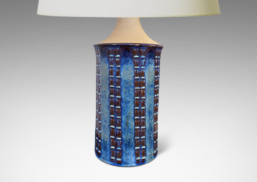 Gallery BAC cylindrical form with flared top, sprouting neck, and ornamented with columns of “I” motifs, partially glazed in a blue luster