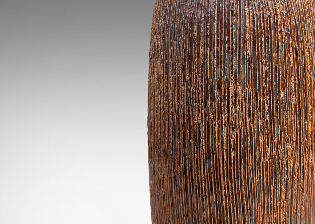 Gallery BAC swelling cylindrical form with a raked texture, glazed in a glossy brown-pale taupe