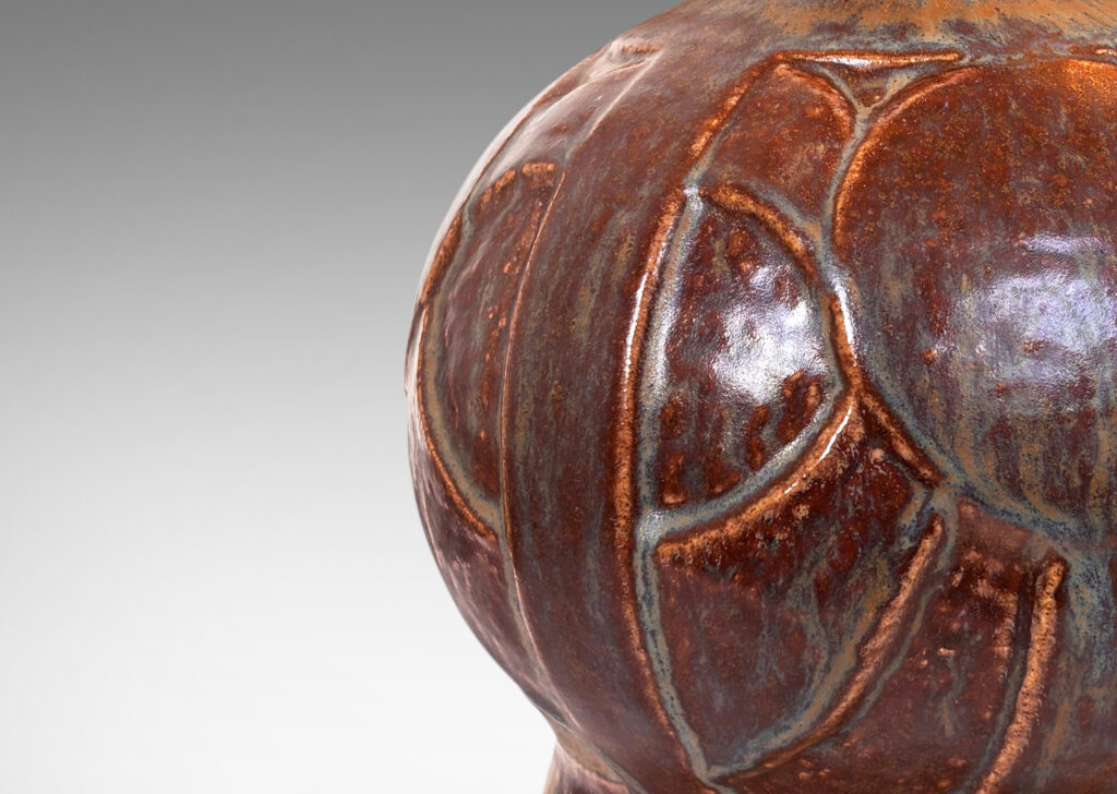 Gallery BAC globe form with geometric reliefs on a flanged foot, glazed in an eggshell finish brown-tan
