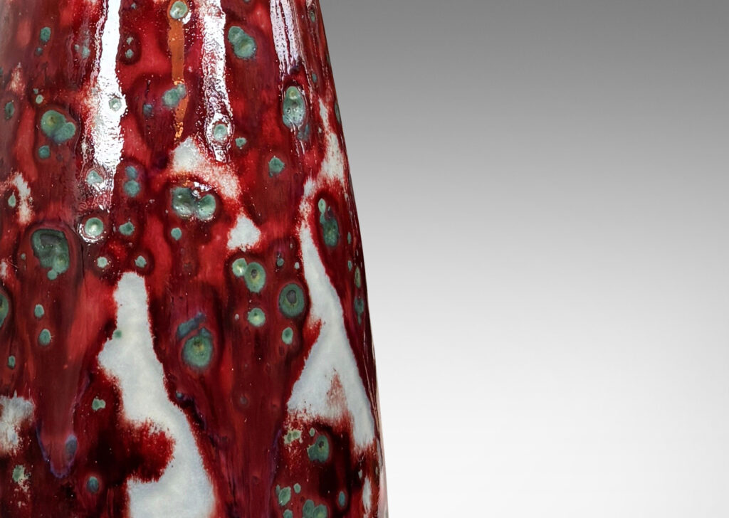 Gallery BAC tall swelling form with outstretched mouth, glazed in oxblood burgundy, with pale gray accents and green-gray dappling