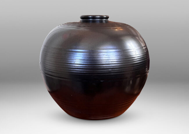 Gallery BAC plump globe form with relief horizontal banding, glazed in a metallic black