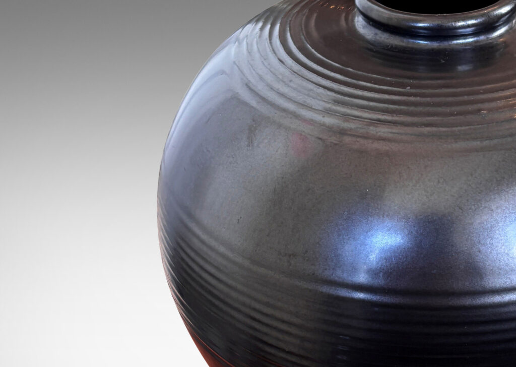 Gallery BAC plump globe form with relief horizontal banding, glazed in a metallic black
