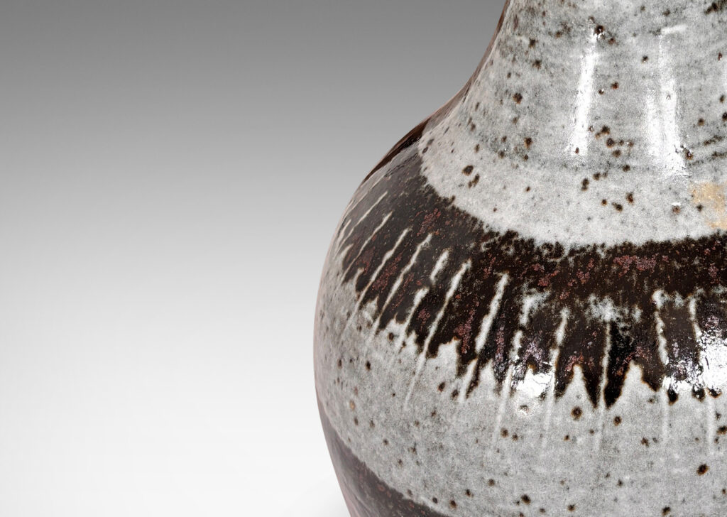 Gallery BAC arge organically modeled pawn / gourd form, glazed in a shiny dappled pale gray with black-red luster bands and strikes