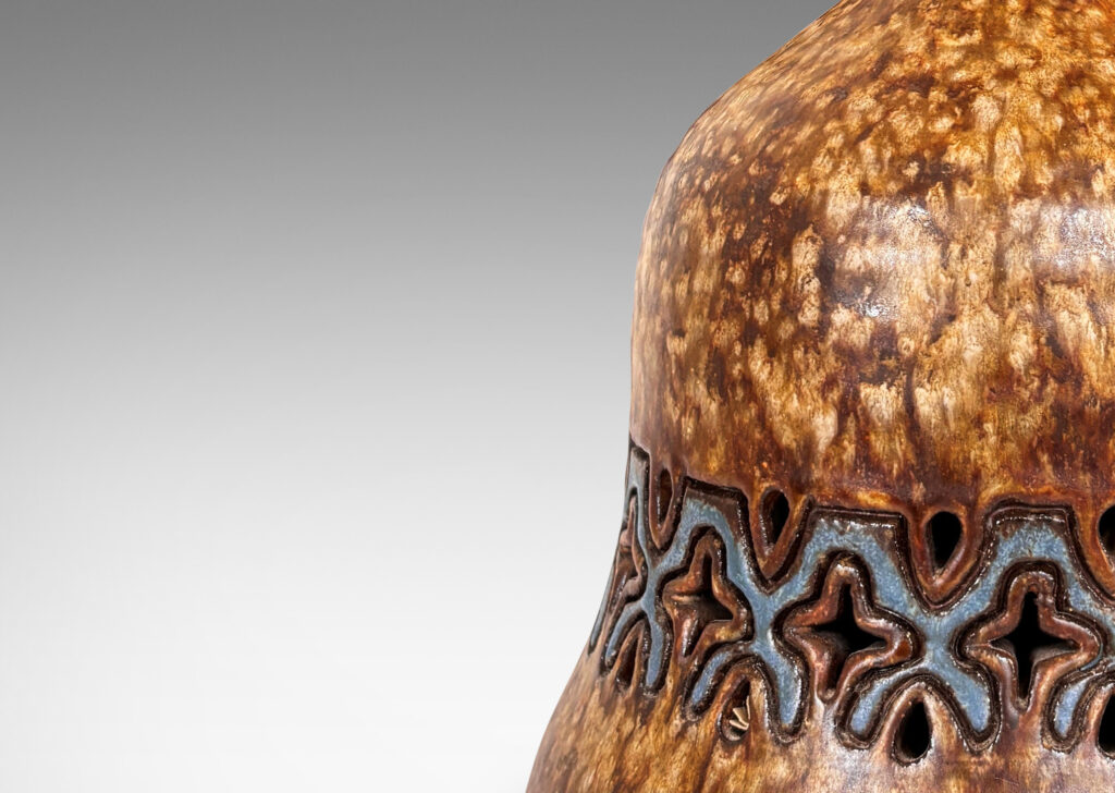 Gallery BAC undulating bell form with carved and openwork ornamental band, glazed in dappled darker overnighter browns, with blue accents