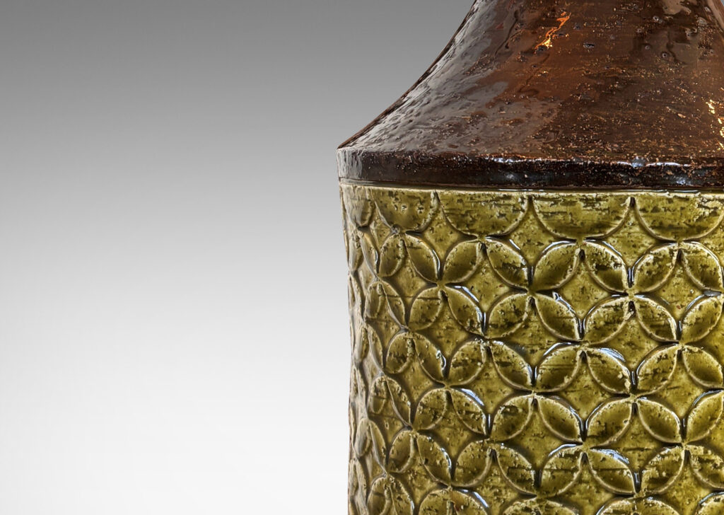 Gallery BAC having a cylindrical form with coved neck and geometric reliefs, glazed in olive green and dark brown