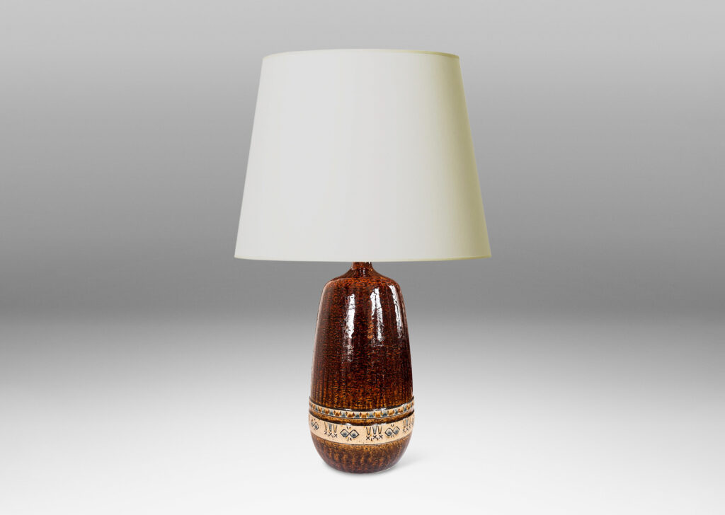 Gallery BAC having grog-textured ovoid cylindrical forms in shiny warm brown with bands of carved geometric designs in ivory, gold and blue