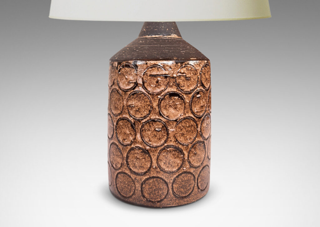 Gallery BAC cylindrical form surrounded in circle motifs, glazed in semi-shine medium brown and matte dark brown
