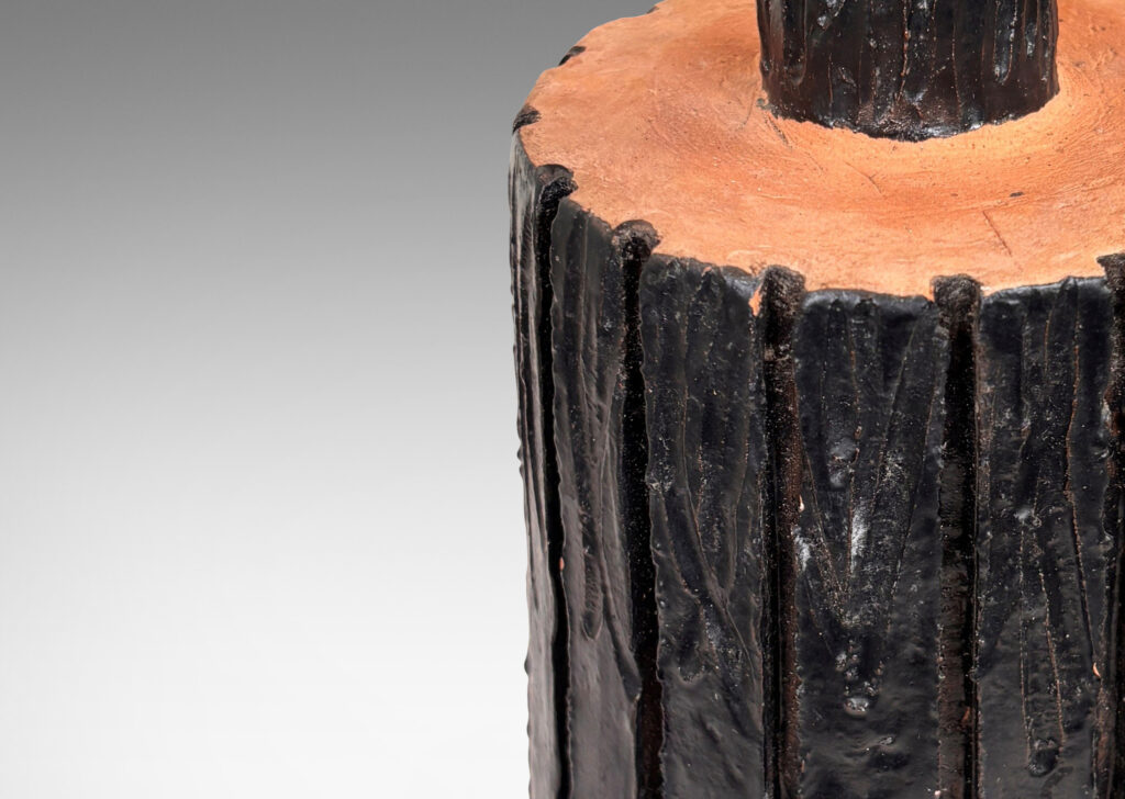 Gallery BAC cylindrical form with carved bark-evoking texture, glazed in a dark black-brown