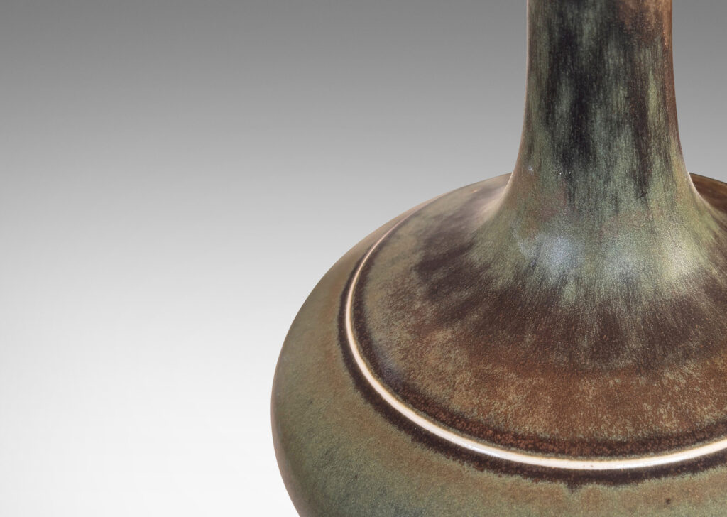 Gallery BAC decanter-like form with a wide compressed base and sprouting neck; glazed in a flowing dark green tones