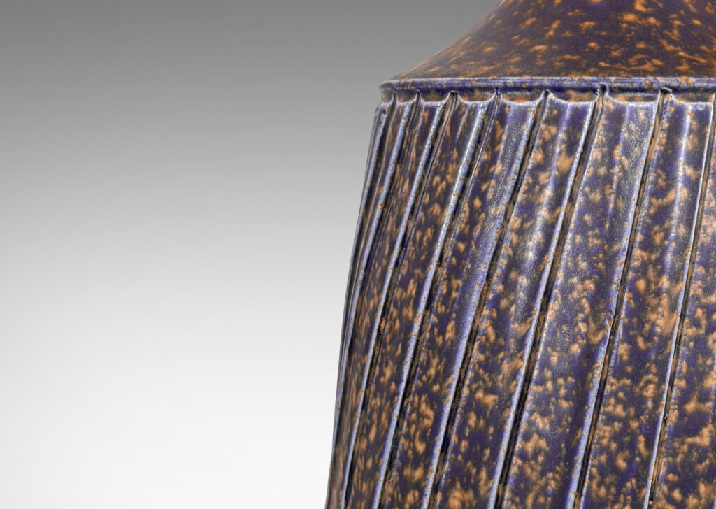 Gallery BAC raked drum form with sprouting neck and carved diagonal ridge design; glazed in sponged dark blue