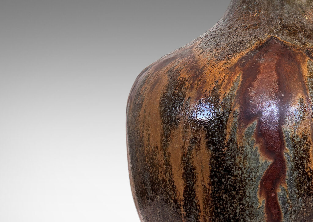 Gallery BAC apple-like form with tall slender neck, glazed in flowing matte light and dark brown over shiny black and gray