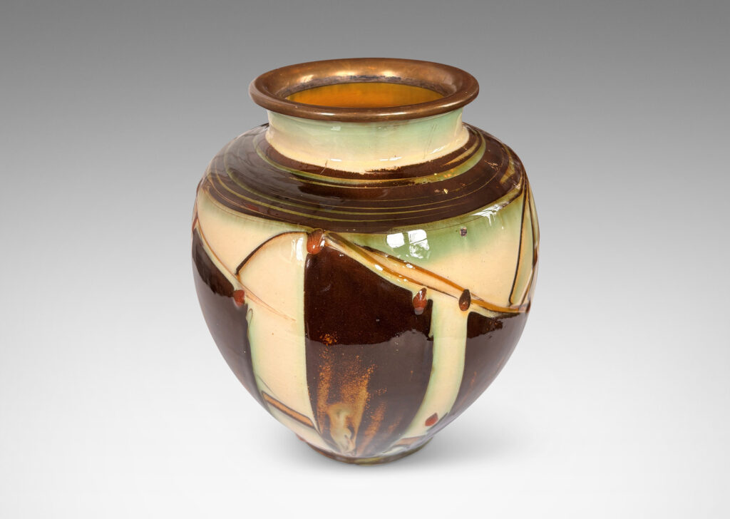 Gallery BAC globe form with angled shoulder and outstretched mouth with brass rim, decorated with a shiny glaze geometric design