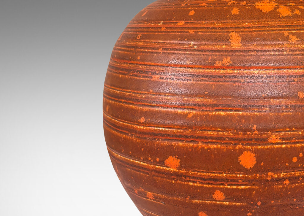 Gallery BAC globe form with carved pinstripe banding, glazed in matte orange-brown and orange