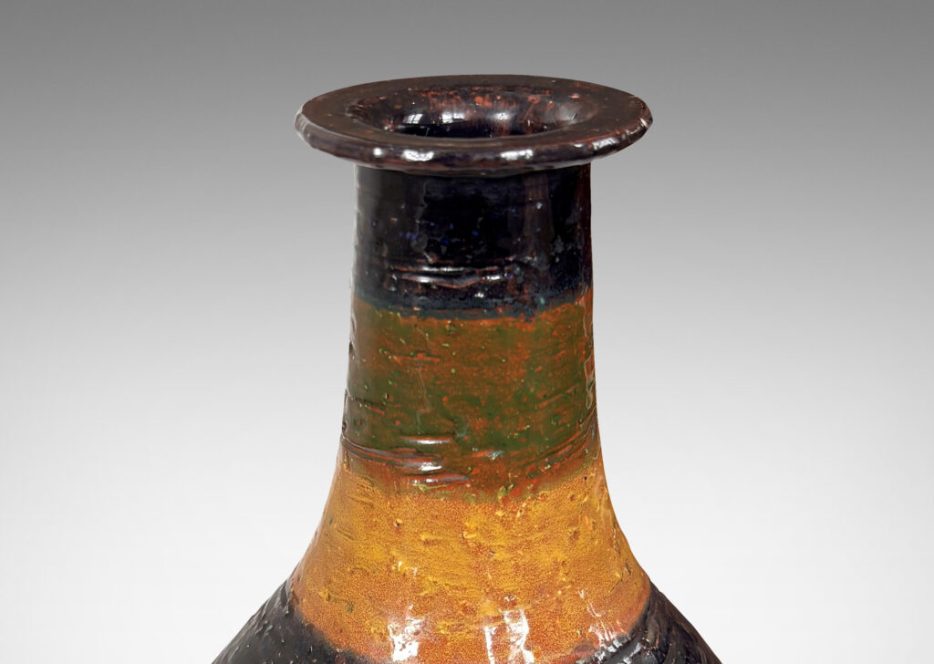 Gallery BAC bulbous form with sprouting neck and flange lip, partially glazed in shiny blue, green and yellow stripes over matte dark brown