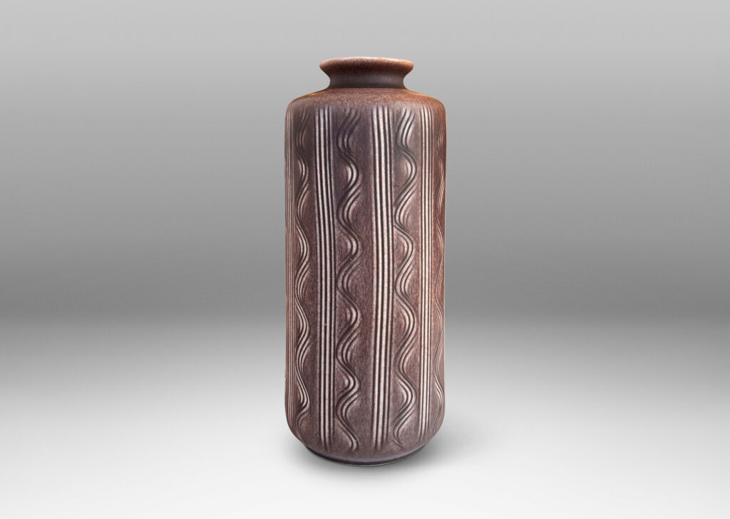 Gallery BAC cylindrical form with carved vertical stripes and waves, and outward curved lip, glazed in an eggshell finish mocha brown