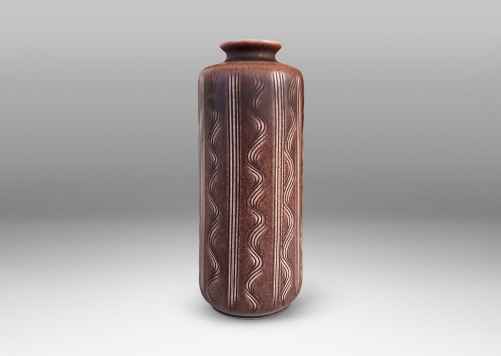 Gallery BAC cylindrical form with carved vertical stripes and waves, and outward curved lip, glazed in an eggshell finish mocha brown
