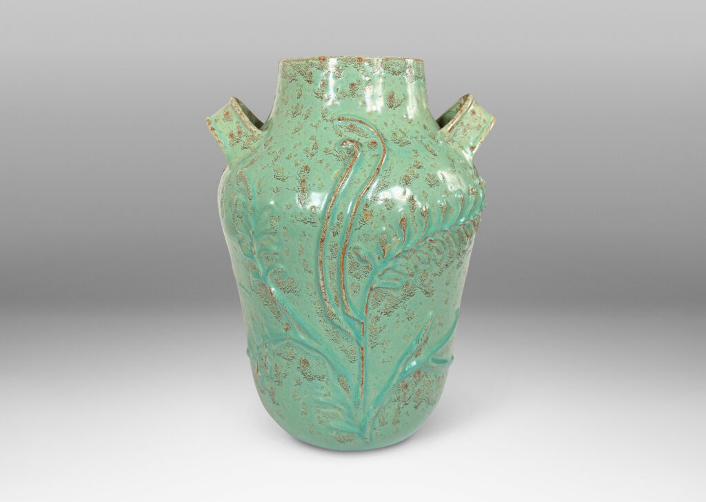 Gallery BAC gourd form with wide mouth, handles, and stylized floral reliefs, glazed in a mottled bright ceadon