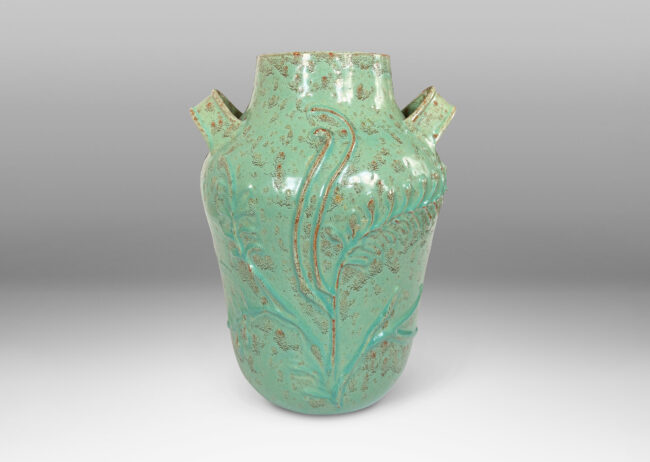 Gallery BAC gourd form with wide mouth, handles, and stylized floral reliefs, glazed in a mottled bright ceadon