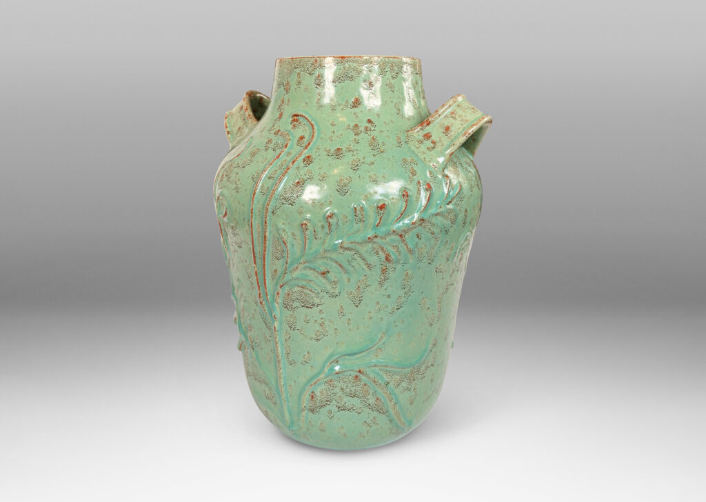 Gallery BAC gourd form with wide mouth, handles, and stylized floral reliefs, glazed in a mottled bright ceadon