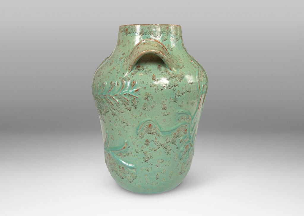 Gallery BAC gourd form with wide mouth, handles, and stylized floral reliefs, glazed in a mottled bright ceadon