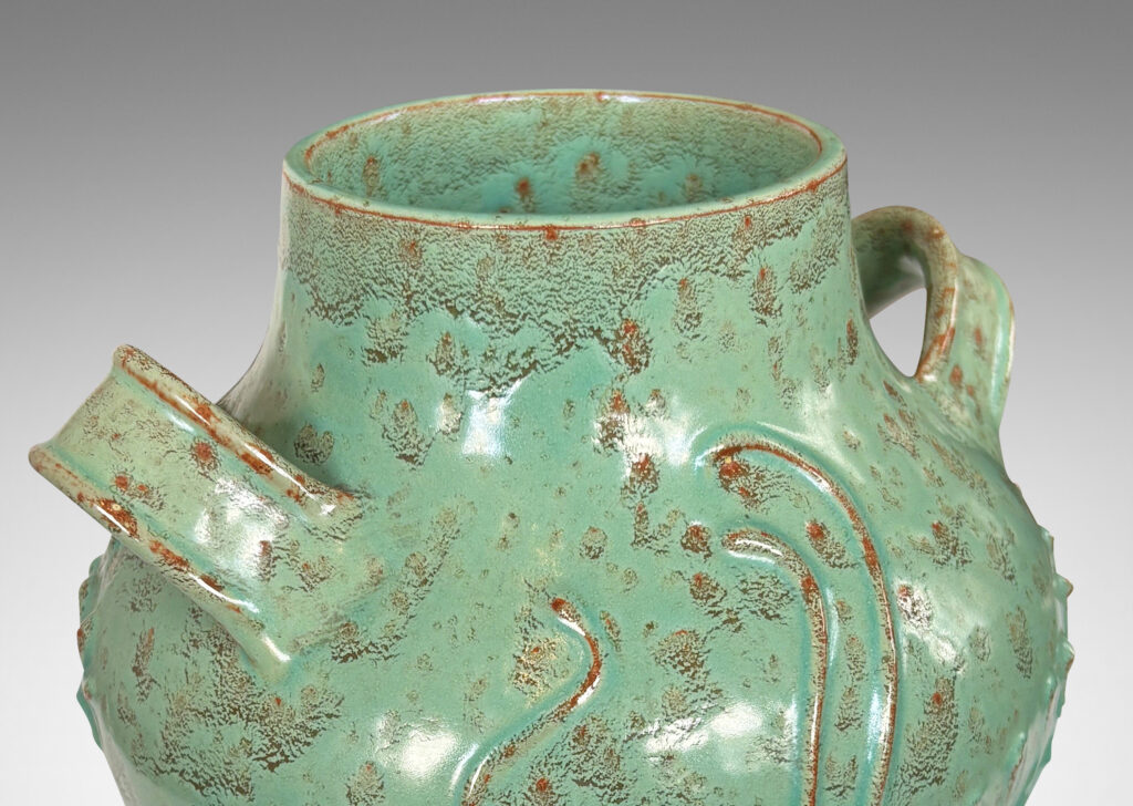 Gallery BAC gourd form with wide mouth, handles, and stylized floral reliefs, glazed in a mottled bright ceadon