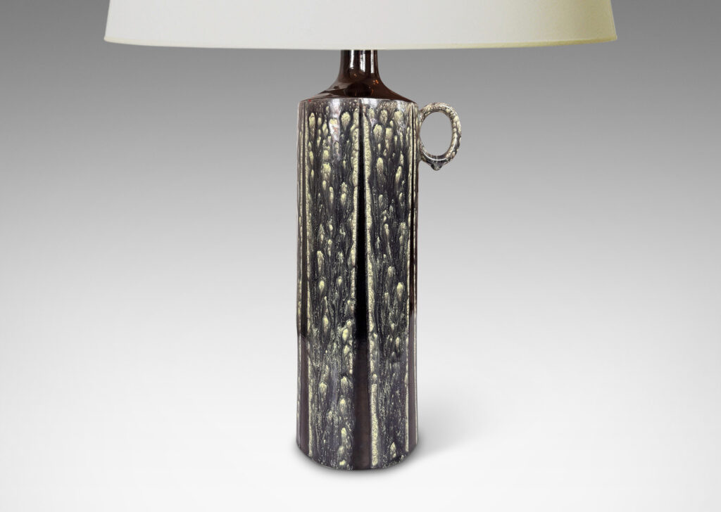 Gallery BAC cylindrical form, with ring handle and spouting mouth, glazed in flowing black-pale celadon