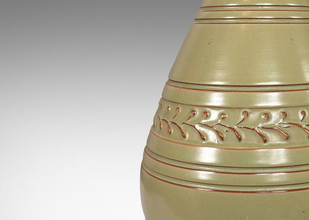 Gallery BAC tall swelling form with carved stripes and ornamental foliate bands, glazed in a pale celadon