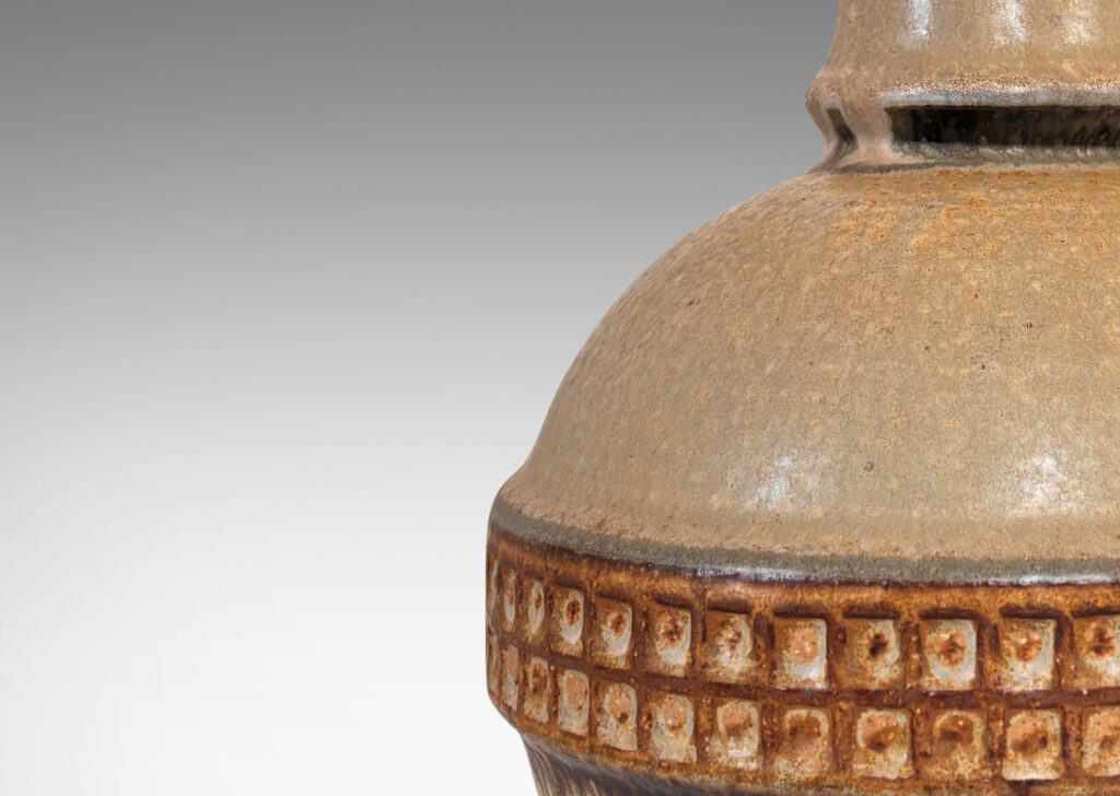 Gallery BAC globe form with notched neck and relief gridded band, glazed in pale beige with brown and gray accents