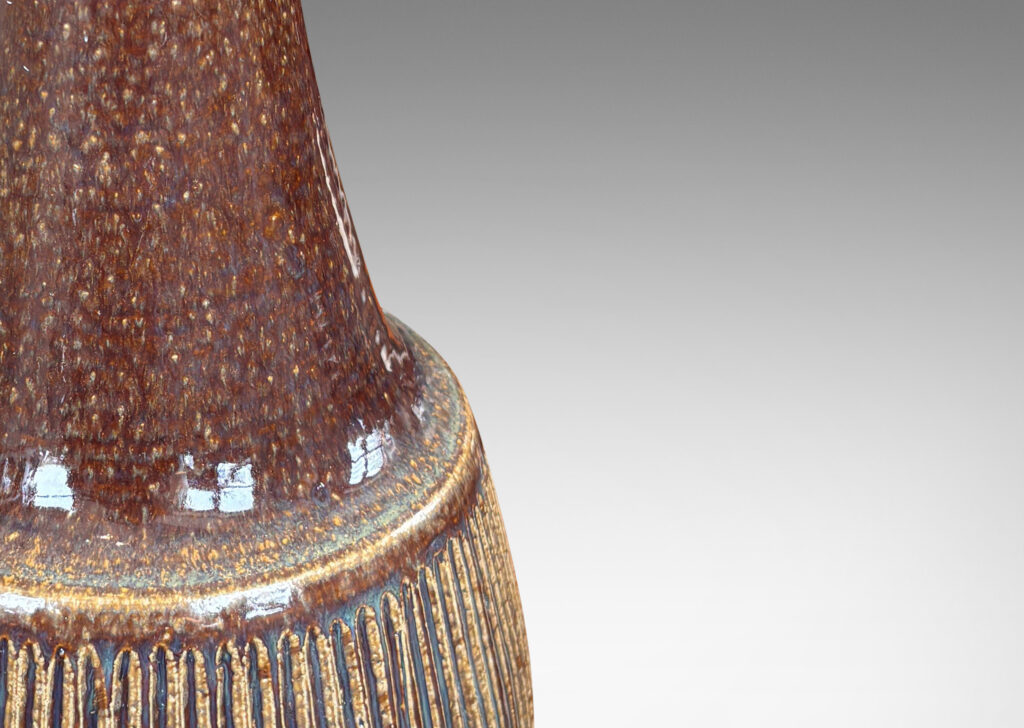 Gallery BAC bulbous form, with swelling ribbed bottom half and wide conical neck above, glazed in dark brown