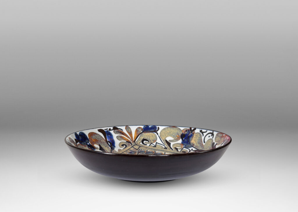Gallery BAC simple arced sides, glazed inside with a rich paisley pattern in brown and blue luster with dark blue, over a pale gray-white, with dark blue exterior