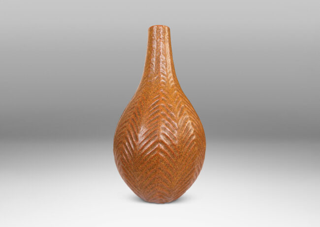 Gallery BAC drop form with slender sprouting neck and carved herringbone pattern, glazed in speckled sandy tan tones