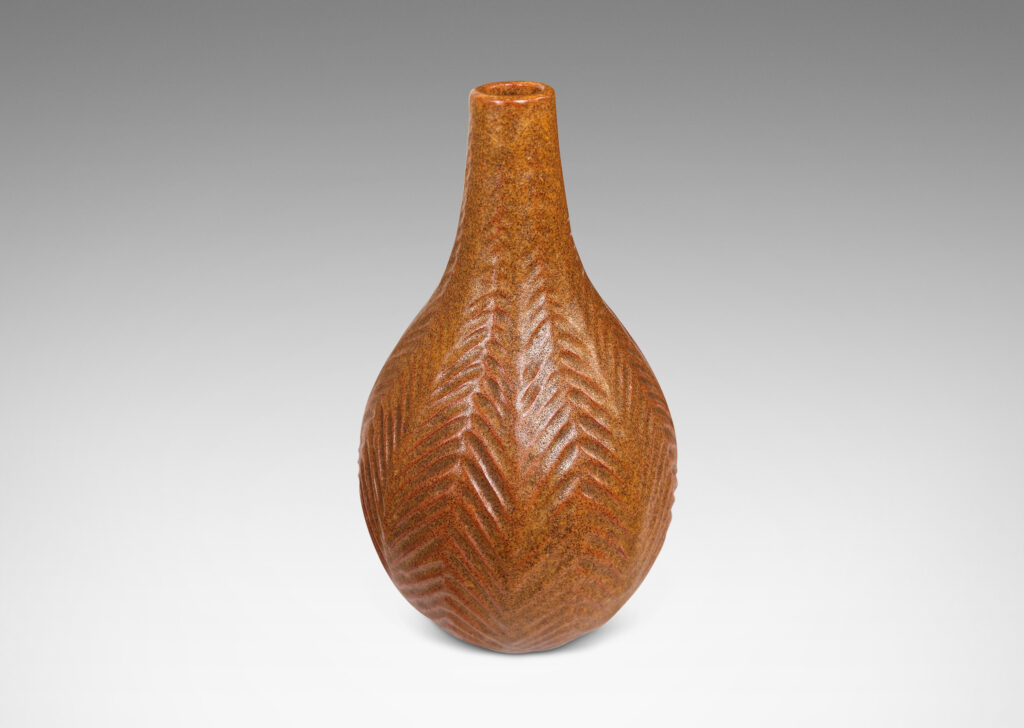 Gallery BAC drop form with slender sprouting neck and carved herringbone pattern, glazed in speckled sandy tan tones