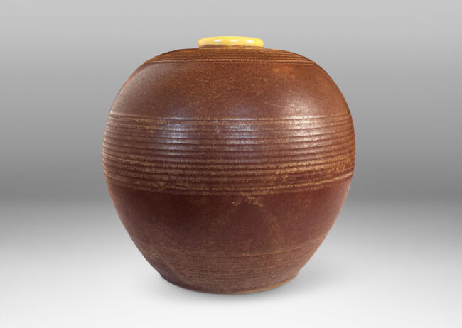 Gallery BAC globe forms with carved pinstripe banding, glazed in brown and yellow