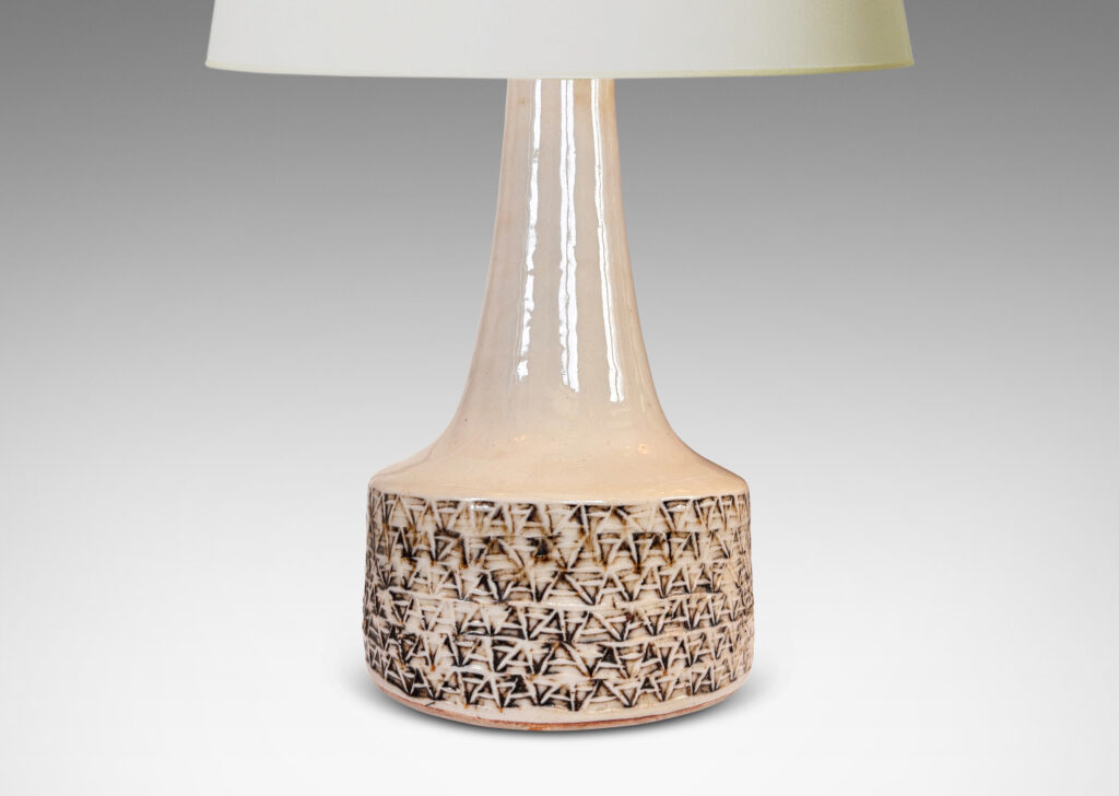 Gallery BAC low drum form with carved relief of triangular motifs and a tall sprouting neck