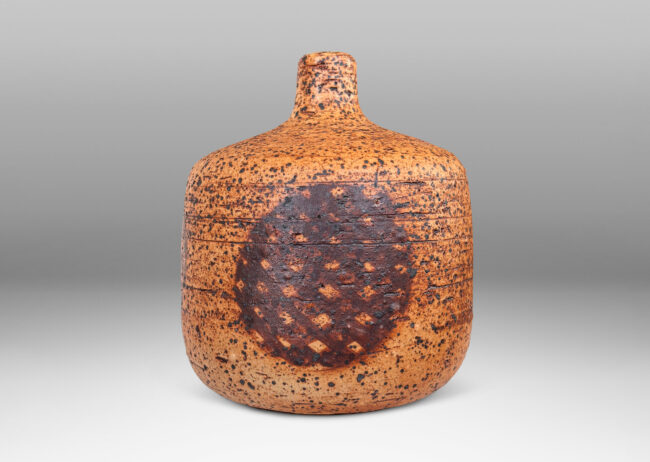 Gallery BAC low cylindrical form with sprouting neck, with wiped brown glaze accentuating grog texture and brown grided circular forms