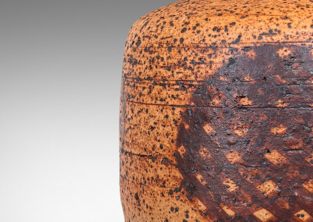 Gallery BAC low cylindrical form with sprouting neck, with wiped brown glaze accentuating grog texture and brown grided circular forms