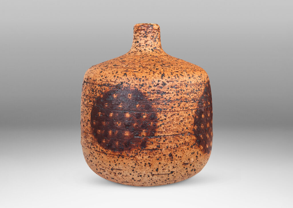 Gallery BAC low cylindrical form with sprouting neck, with wiped brown glaze accentuating grog texture and brown grided circular forms