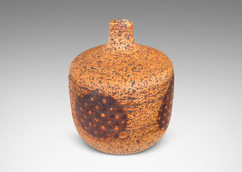 Gallery BAC low cylindrical form with sprouting neck, with wiped brown glaze accentuating grog texture and brown grided circular forms