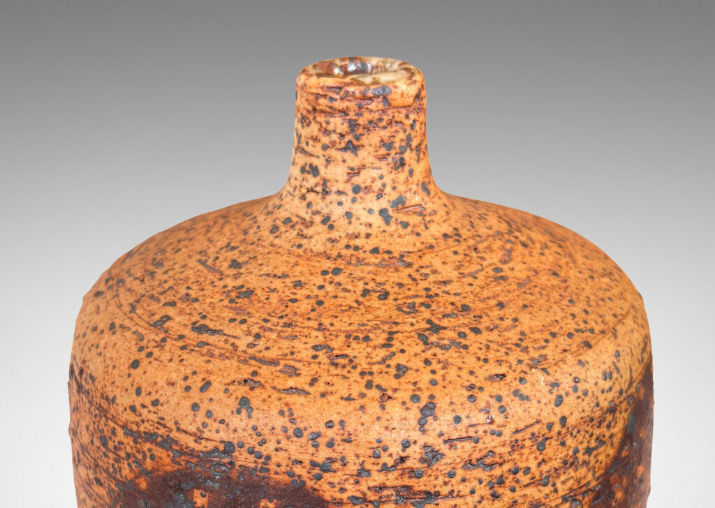 Gallery BAC low cylindrical form with sprouting neck, with wiped brown glaze accentuating grog texture and brown grided circular forms
