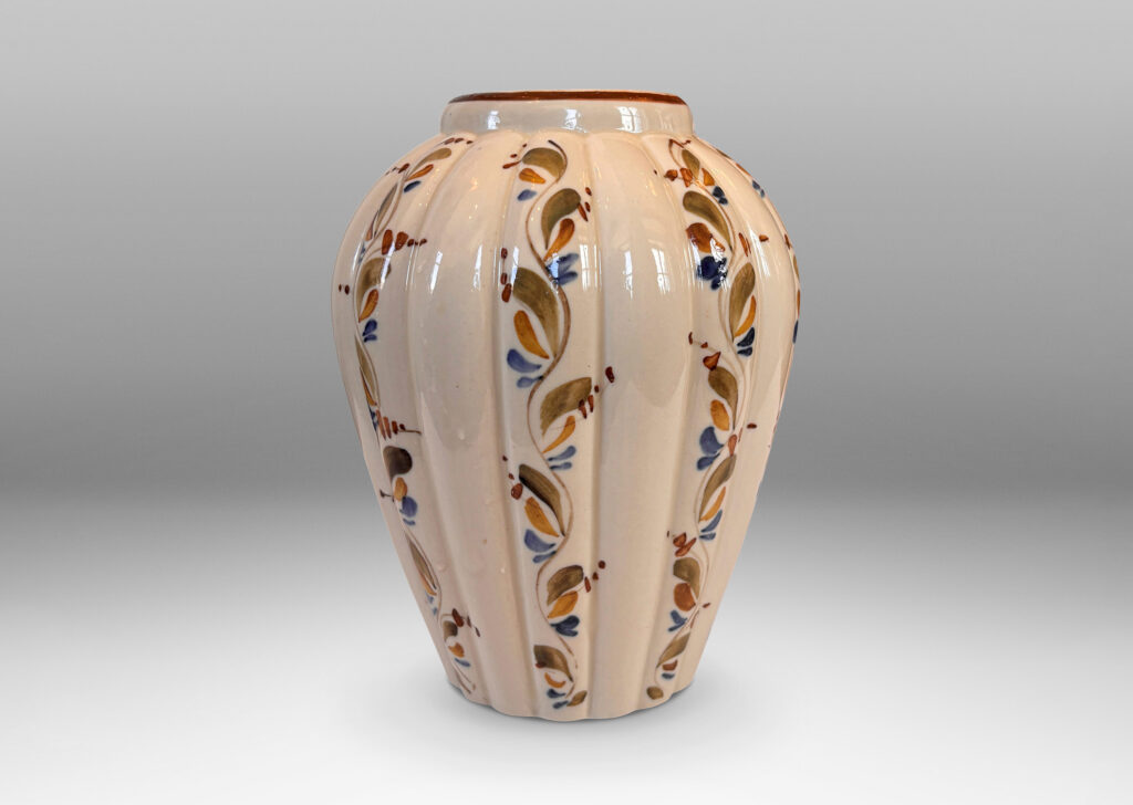 Gallery BAC vertically lobed tapered form, glazed in ivory with hand-painted foliage ornaments in drab green, brown and blue