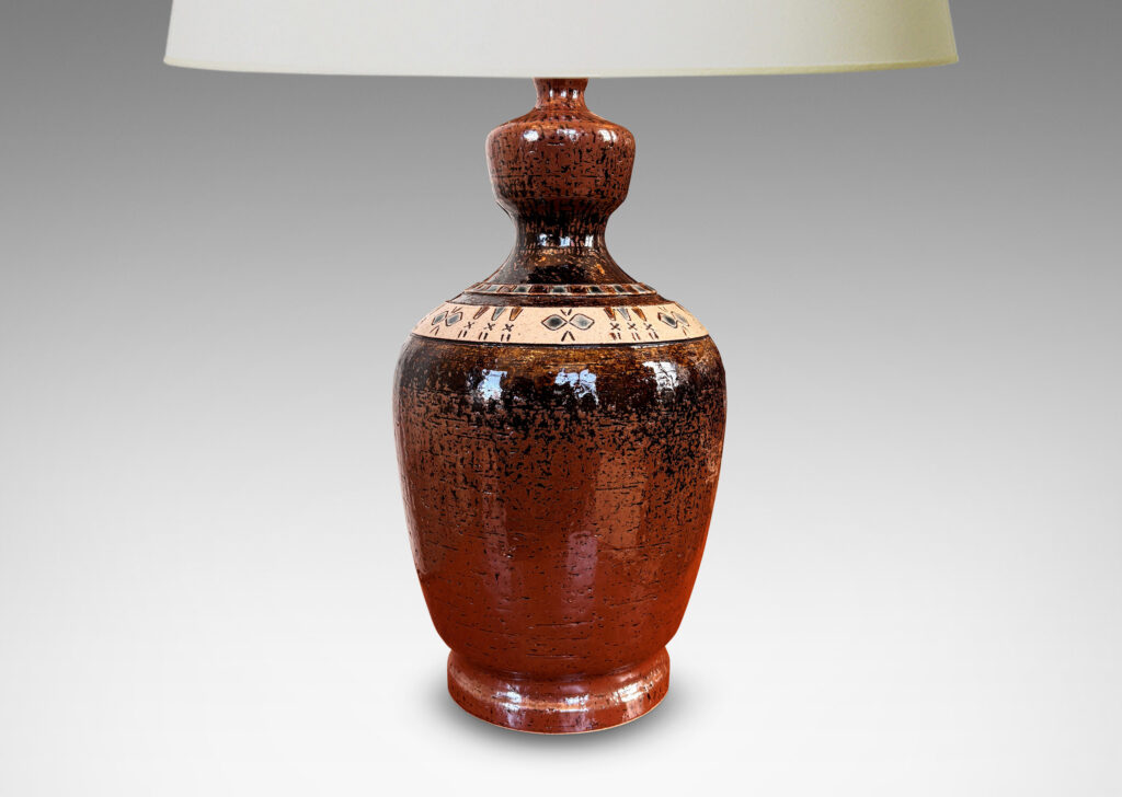 Gallery BAC urn style tapered ovoid form with textured surface with bands of carved geometric designs, glazed in brown, with ivory and gray-blue