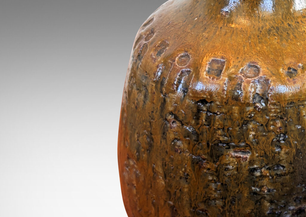 Gallery BAC plump ovoid form with grog texture and geometric motifs impressed around shoulder, glazed in olive brown