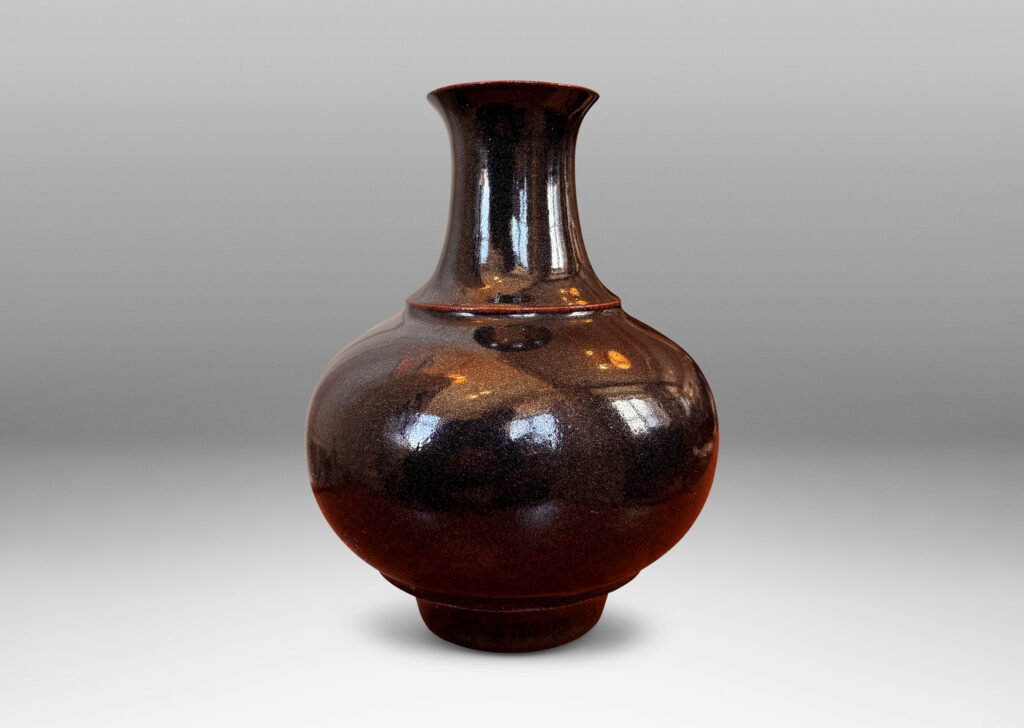 Gallery BAC compressed globe form with wide cove neck, glazed in shiny black with hints of oxblood red